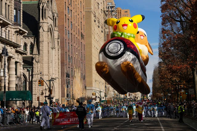 Balloon handlers guide the Pikachu & Eevee balloon down Central Park West during the Macy’s Thanksgiving Day Parade in New York