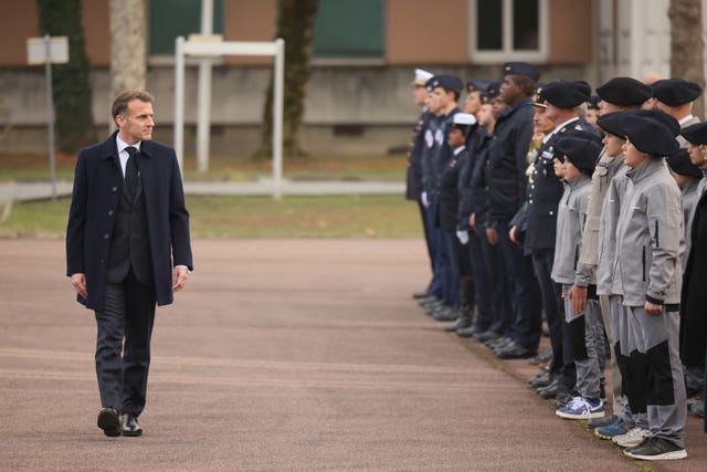 Emmanuel Macron reviewing troops and students of an army high school