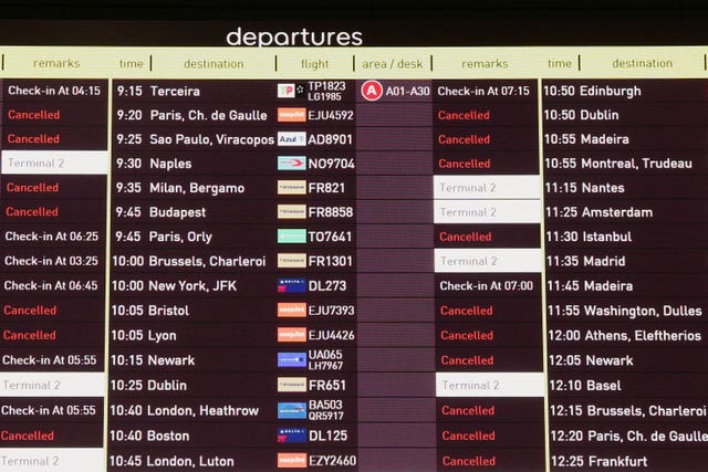 A screen shows cancelled flights at Lisbon Airport