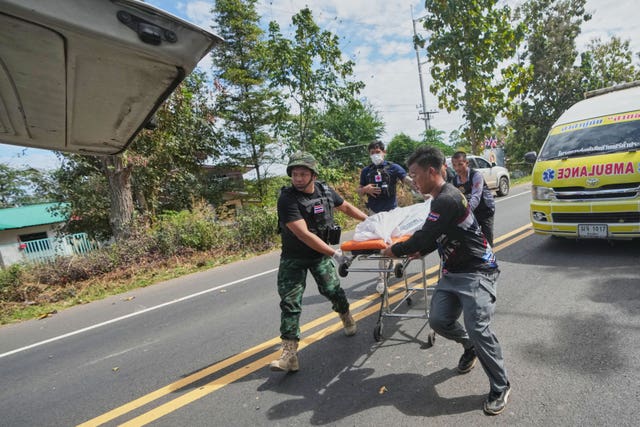 Thai rescue team members move a body into a vehicle after a Cambodian artillery strike in Sisaket province