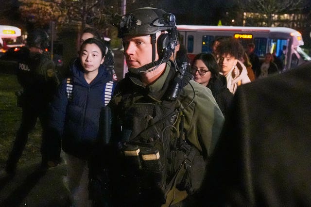 Students are escorted by law enforcement officers to a building at Brown University after the shooting