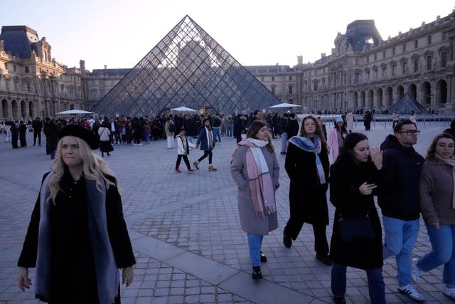 Visitors leave the Louvre museum shortly before workers voted to strike for the day