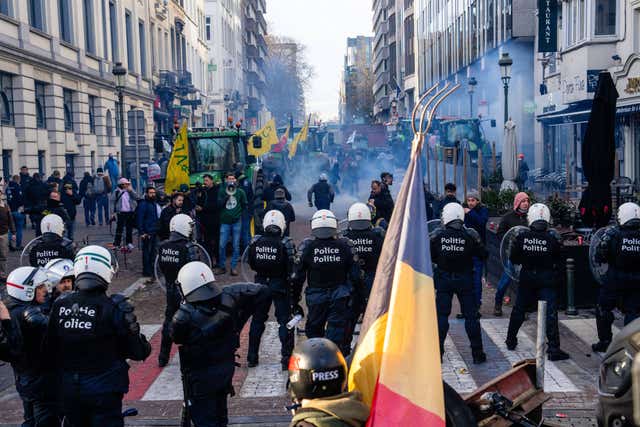 Police try to disperse protesters during a demonstration of European farmers near the European Parliament in Brussels