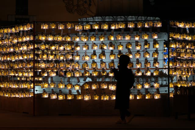 A Buddhist prays in front of lanterns on New Year’s Eve at a temple in Seoul, South Korea