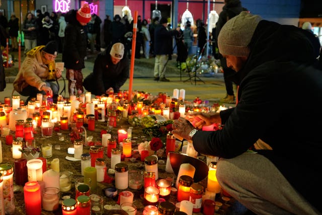 People lighting candles