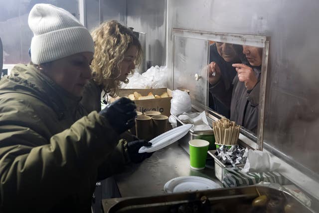 Free hot meals are served in a residential neighbourhood in Kyiv for people without power in their homes