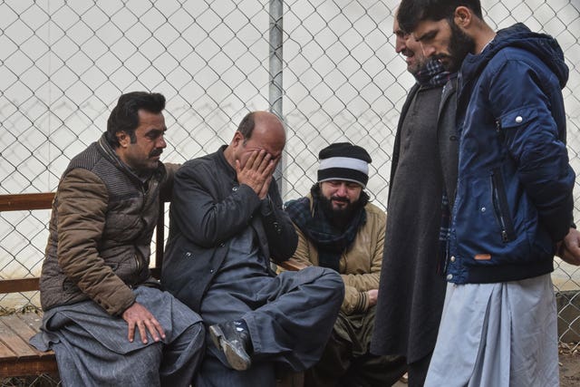 Relatives of police officers who were killed in a militants attack mourn outside a hospital in Quetta