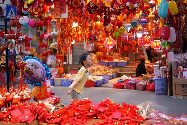 A young girl runs with a balloon at Hang Luoc traditional Tet market