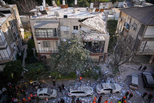 Officers from Israel’s Home Front Command inspect a damaged apartment building after an Iranian missile strike in Ramat Gan, Israel