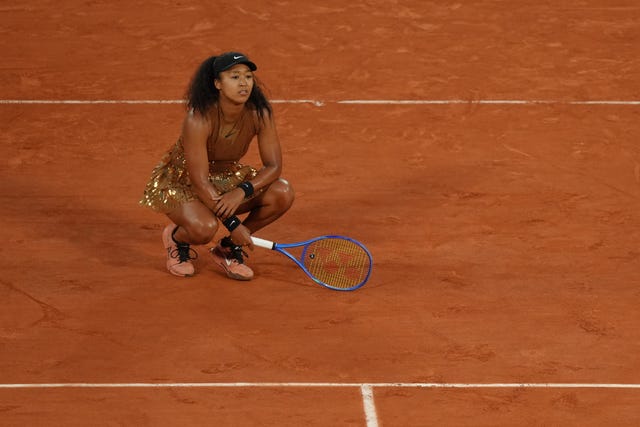 Naomi Osaka crouches down on the clay