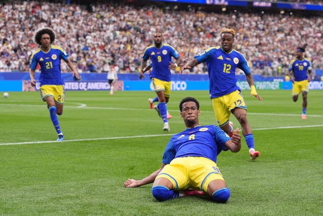 Curacao’s Livano Comenencia celebrates with a knee-slide after scoring against Germany