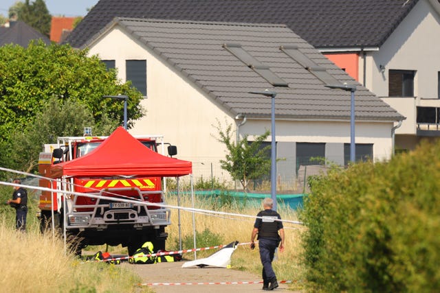 A police officer stands near the site where a skydiving plane crashed in France