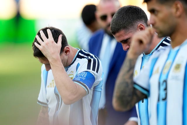 Argentina’s Lionel Messi, from left, Rodrigo De Paul and Cristian Romero react at the end of the World Cup final