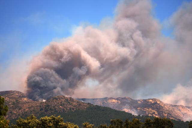 Smoke and flames rise as a wildfire advances near La Adrada in Spain