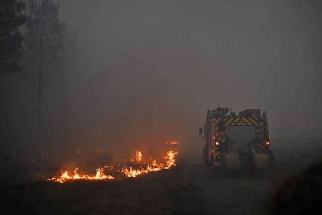 A fire engine drives through smoke of a wildfire raging near Marcheprime, outside, Bordeaux, France