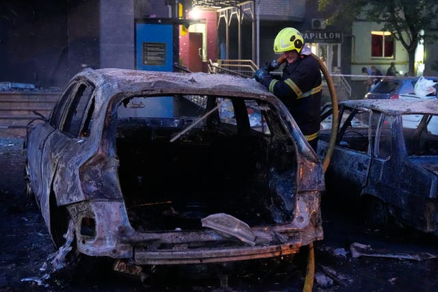 Emergency services personnel work to extinguish a fire width=