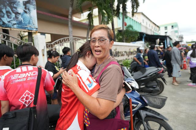 A schoolgirl cries outside her school 