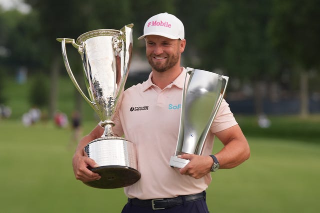 Wyndham Clark holds the Wanamaker Trophy and the BMW trohy after winning the BMW Championship