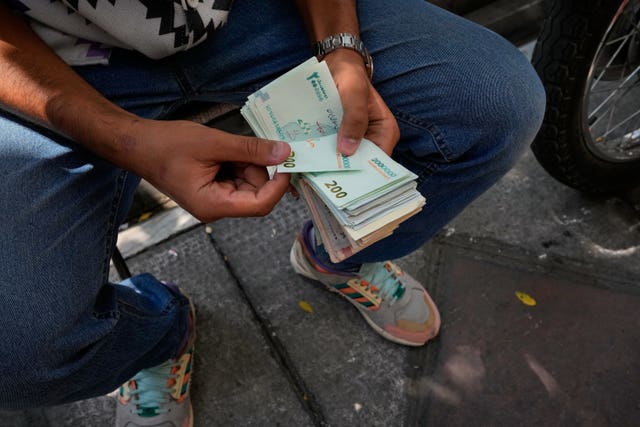 A money exchanger counts Iranian banknotes in Tehran