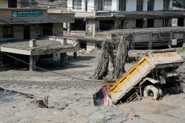 Damaged houses and vehicles are seen in the aftermath of flash floods along the Trishuli River