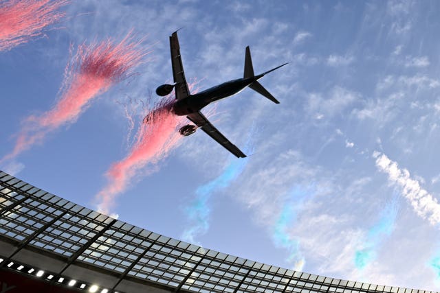 A jet flies over a stadium