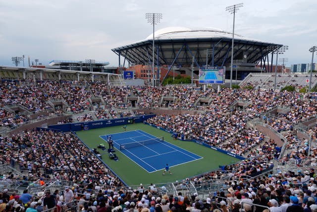 A crowd watches Stan Wawrinka, of Switzerland, bottom, competes against Matteo Berrettini