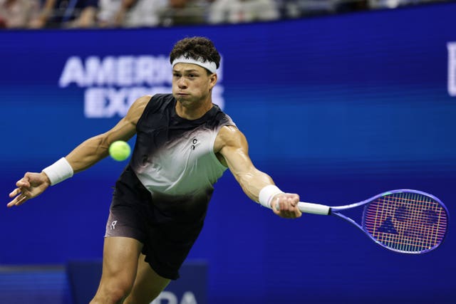 Ben Shelton returns against Stefanos Tsitsipas