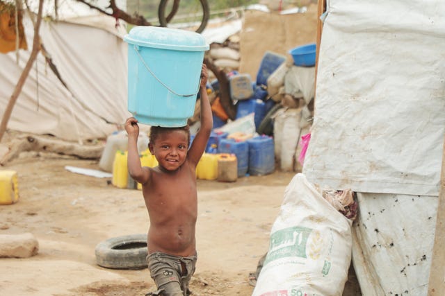 A child carries a bucket