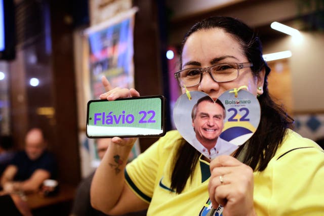 A supporter of opposition presidential candidate Flavio Bolsonaro poses for a picture as she waits for election results in Rio de Janeiro