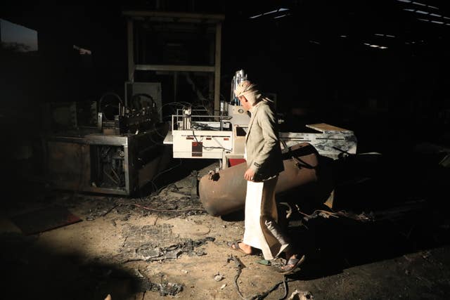 A man walks inside a damaged sponge factory in Sanaa, Yemen