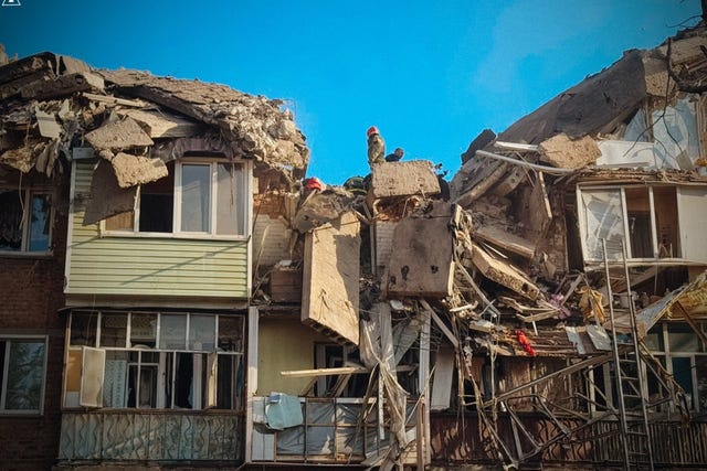 Rescuers work at the scene of a building destroyed following Russian attacks in Pryluky, Chernihiv region, Ukraine