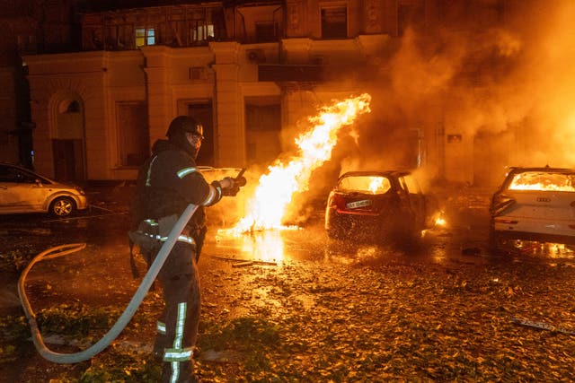 A firefighter puts out a fire following a Russian air attack at a residential building in Kharkiv, Ukraine