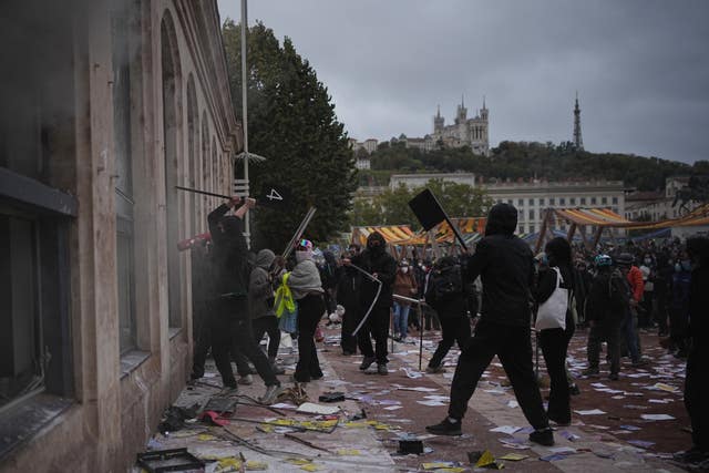 Protesters attack a tourism office during a demonstration against rising living costs, joining students’ grievances, in Lyon, France
