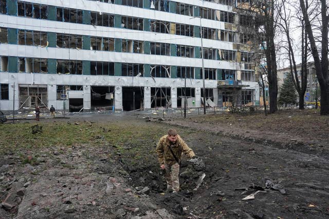 A Ukrainian serviceman inspects a missile crater after a Russian air attack in central Kyiv