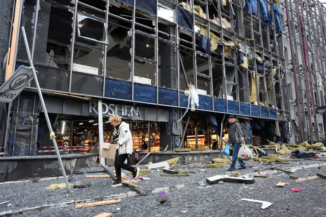 People carry their belongings as they leave their office following a Russian air attack in Kyiv, Ukraine