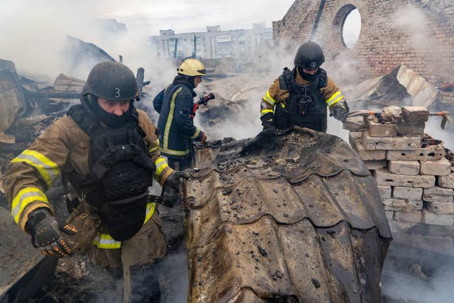 Rescuers work on the roof of the damaged building in Kharkiv