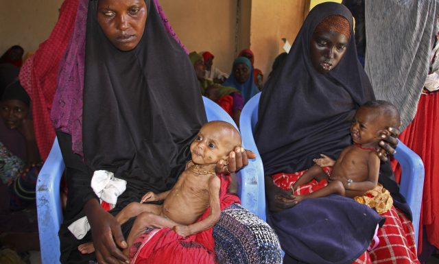 Mothers hold malnourished babies at a feeding camp (Farah Abdi Warsameh/AP)