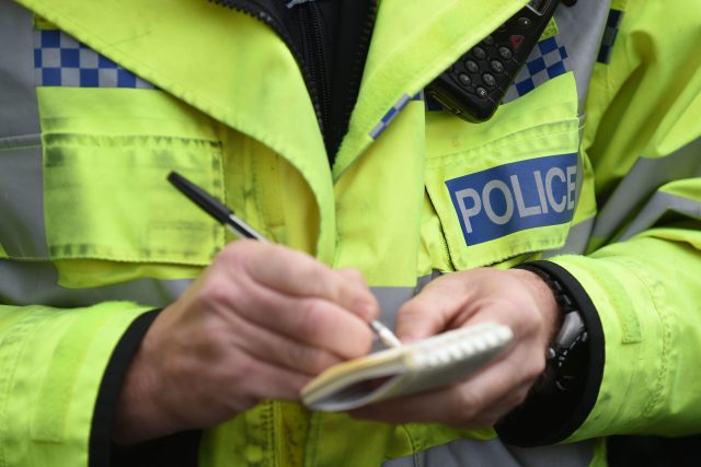 A policeman writing on a notepad