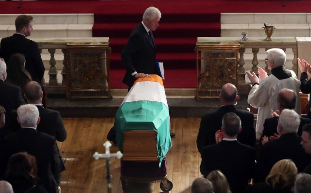 Former US President Bill Clinton touches the coffin