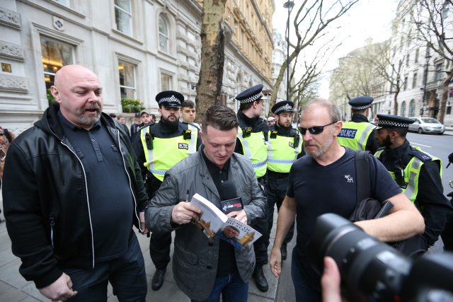 Former EDL spokesman and leader Tommy Robinson signs a copy of his book during the protest (Jonathan Brady/PA)