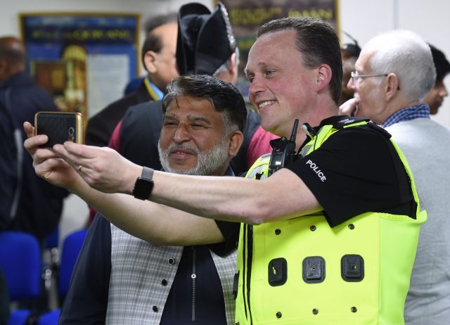 West Midlands Chief Superintendent Chris Johnson takes a selfie with Makhdoom Ahmad Chisti. (Joe Giddens/PA)