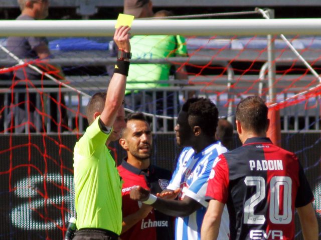 Referee Daniele Minelli shows the yellow card to Pescara's Sulley Muntari, second from right, during a Serie A soccer match between Pescara and Cagliari (Fabio Murru/ANSA/AP)