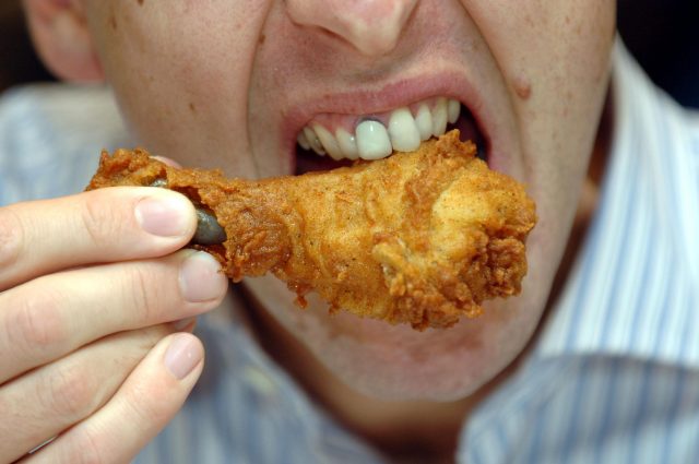 A man eats chicken from a fast food (Steve Parsons/PA)