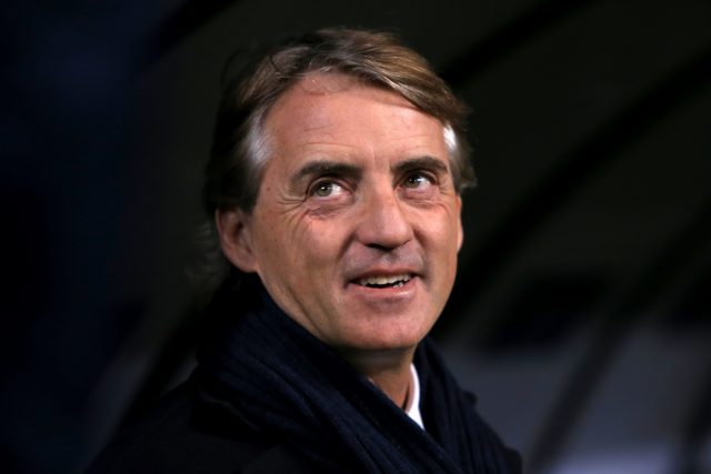 Roberto Mancini smiles as he looks up to the stands