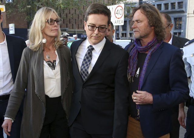 Thomas Zinn, centre, the partner of Lindt Cafe siege victim Tori Johnson walks with Rosie Connellan, left, and Ken Johnson, the parents of Johnson, after attending the Lindt Cafe siege inquest findings in Sydney (David Moir/AAP Image via AP)