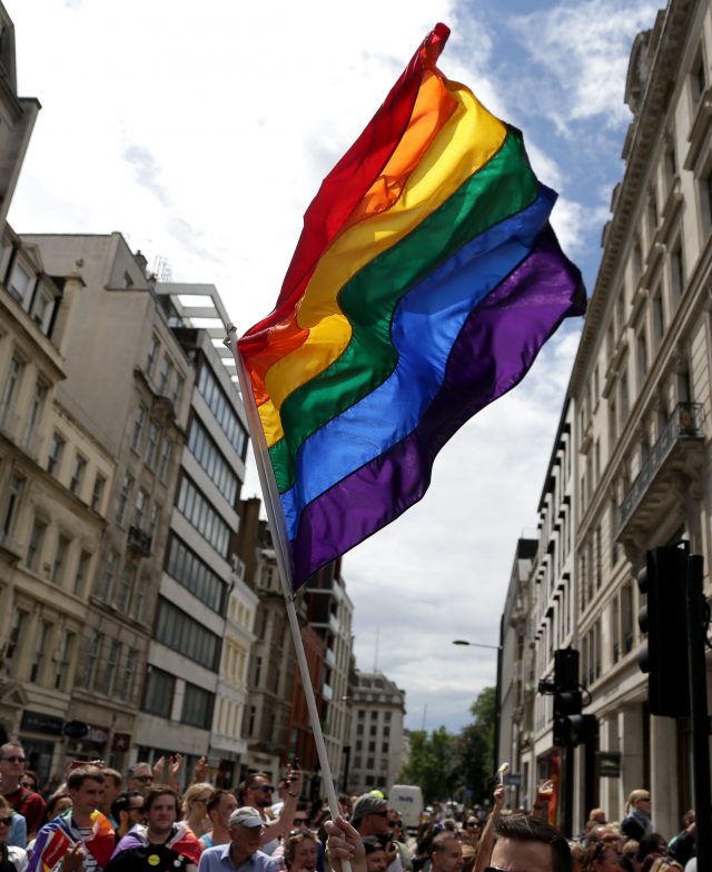 A rainbow flag is held aloft as the Pride in London parade makes its way through the streets (Daniel Leal-Olivas/PA)
