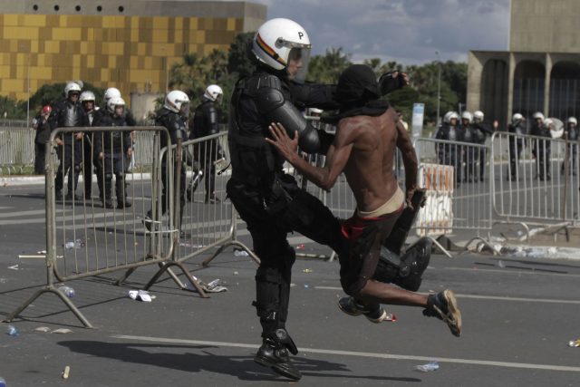 A demonstrator clashes with a policeman in Brazil