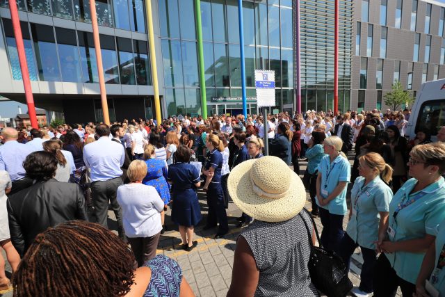People observe a minute's silence outside the Royal Manchester Children's Hospital (Peter Byrne/PA)