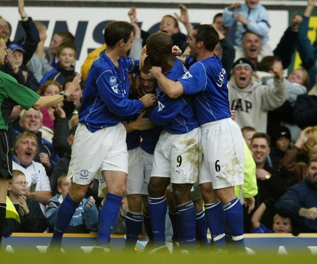 Wayne Rooney is mobbed by team-mates after scoring his first Premier League goal