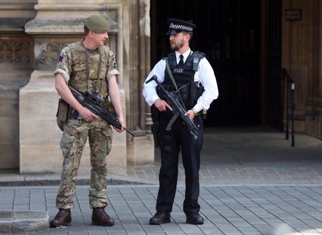 Members of the army join police officers outside the Palace of Westminster